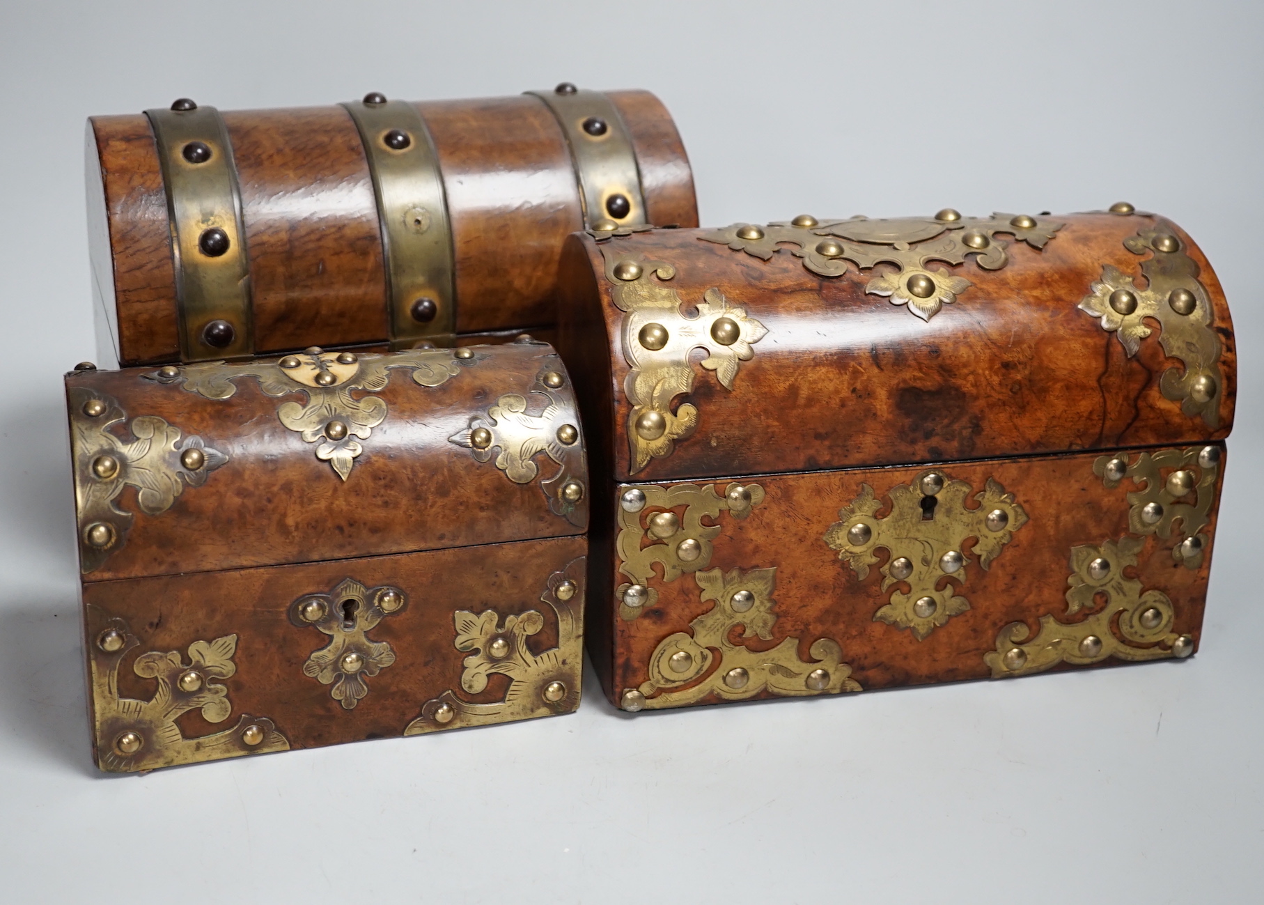 Three Victorian walnut domed topped and brass mounted caskets, largest 23cm wide x 17cm high